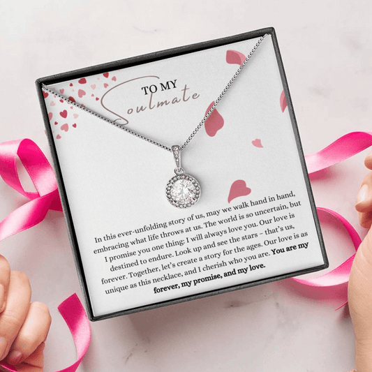 A woman unwrapping necklace gift, with a big cubic zirconia crystal pendant and a white gold finish, with a message card a soulmate.