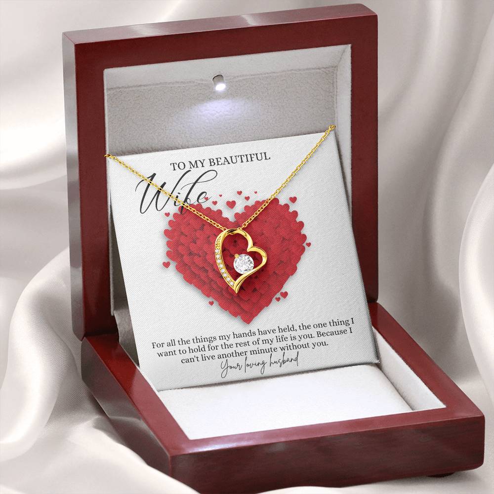 A yellow gold finish necklace gift, featuring a stunning 6.5mm CZ crystal surrounded by a polished heart pendant embellished with smaller crystals, with a message card to my beautiful wife, in a mahogany Jewelry box. 