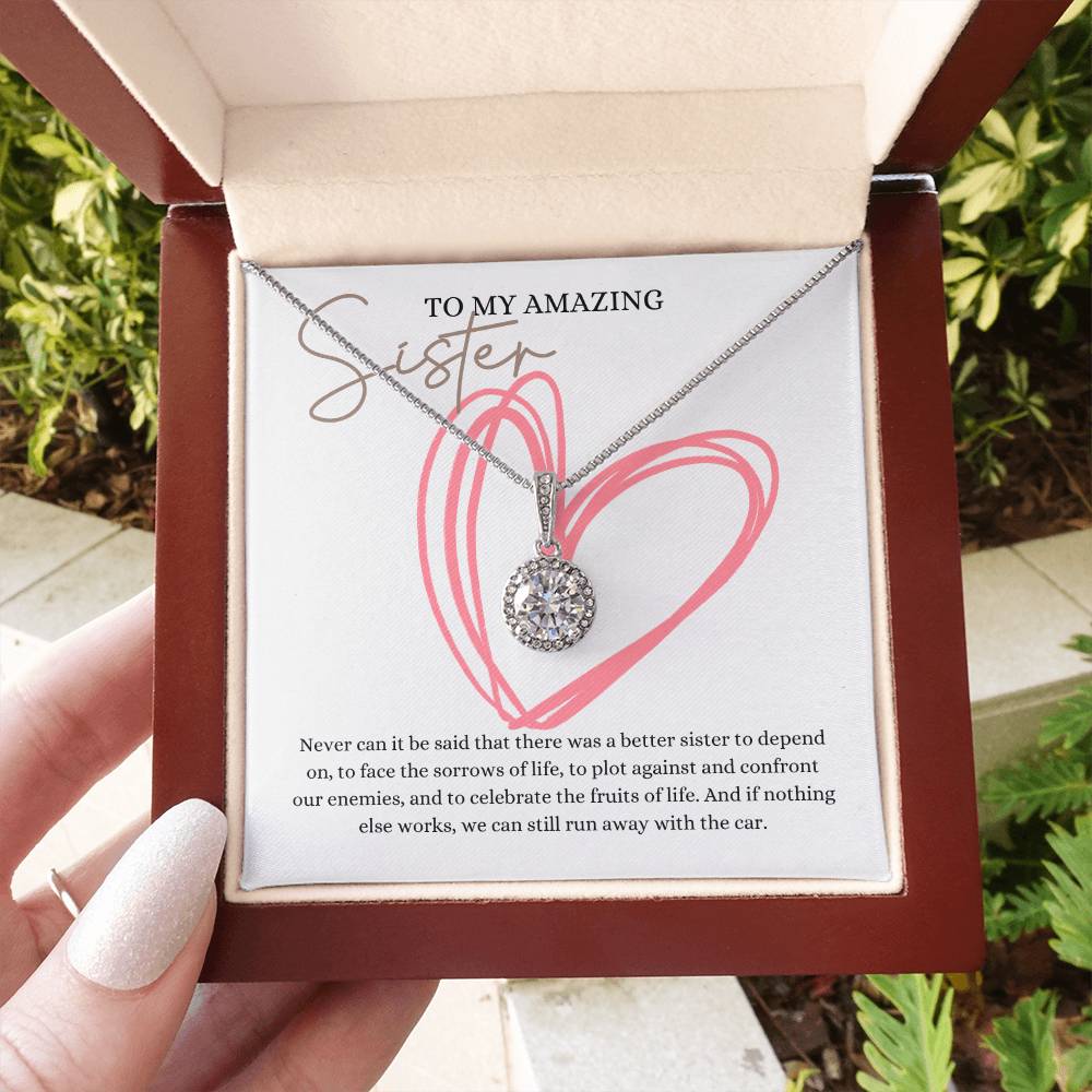 A woman holding a mahogany Jewelry box with a big cubic zirconia crystal pendant and a white gold finish, with a message card to my amazing sister.