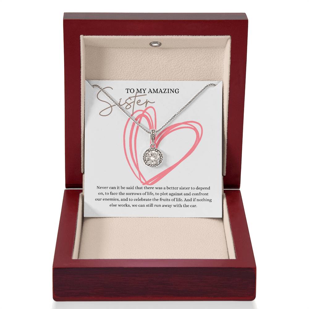 A necklace gift with a big cubic zirconia crystal pendant and a white gold finish, with a message card to my amazing sister, in a mahogany Jewelry box.