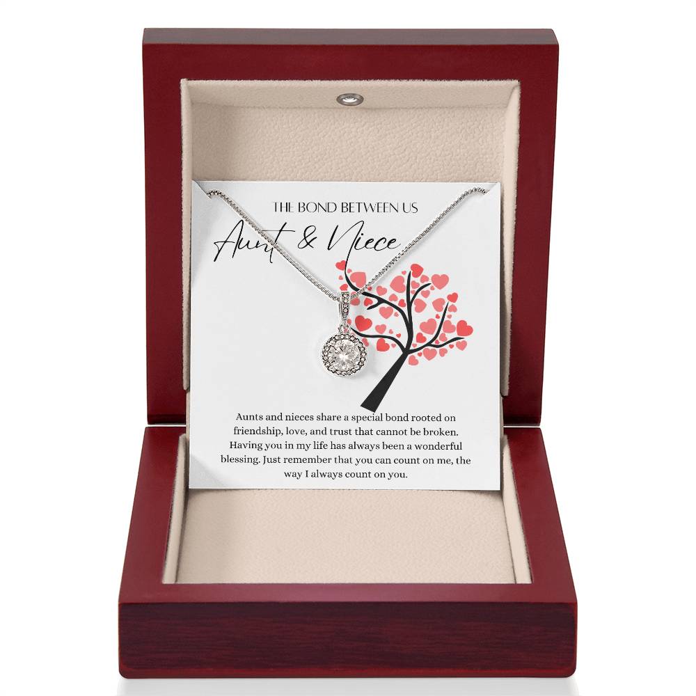 A necklace gift with a big cubic zirconia crystal pendant and a white gold finish, with a message card to for aunts and nieces, in a mahogany Jewelry box.