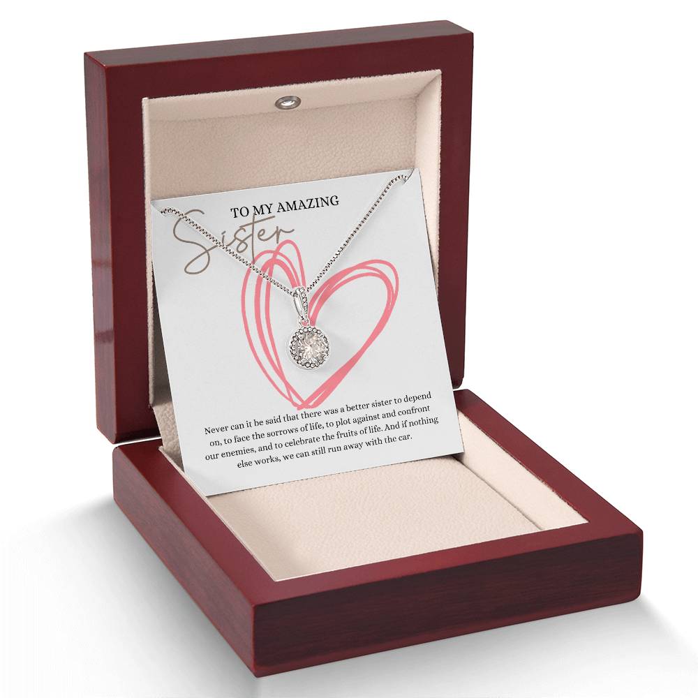 A necklace gift with a big cubic zirconia crystal pendant and a white gold finish, with a message card to my amazing sister, in a mahogany Jewelry box