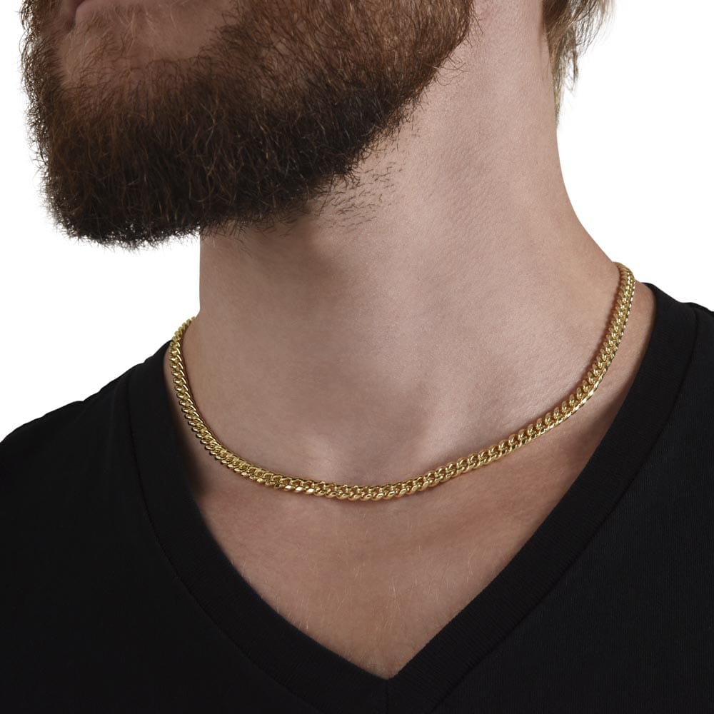 A man wearing a Cuban chain necklace with a yellow gold finish.