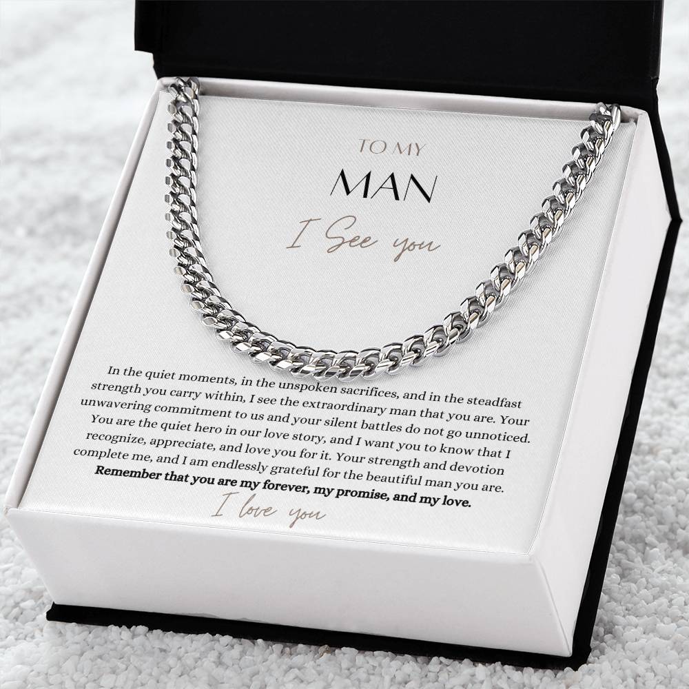 A Cuban chain necklace gift and a white gold finish, with a message card that says to my man, in a Jewelry box on a white carpet.