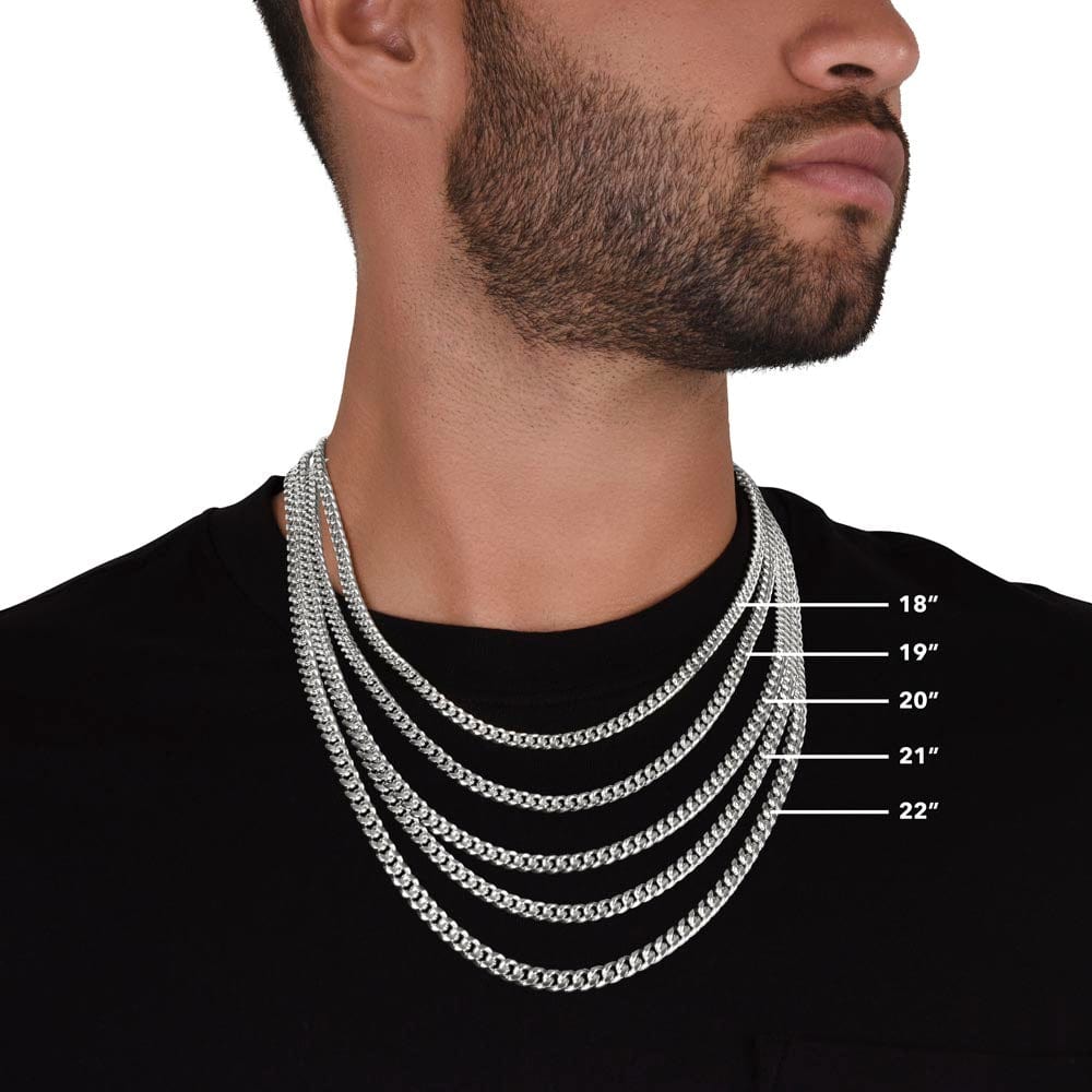 A man wearing multiple Cuban chain necklace with a white gold finish showing the possible length of the necklace.