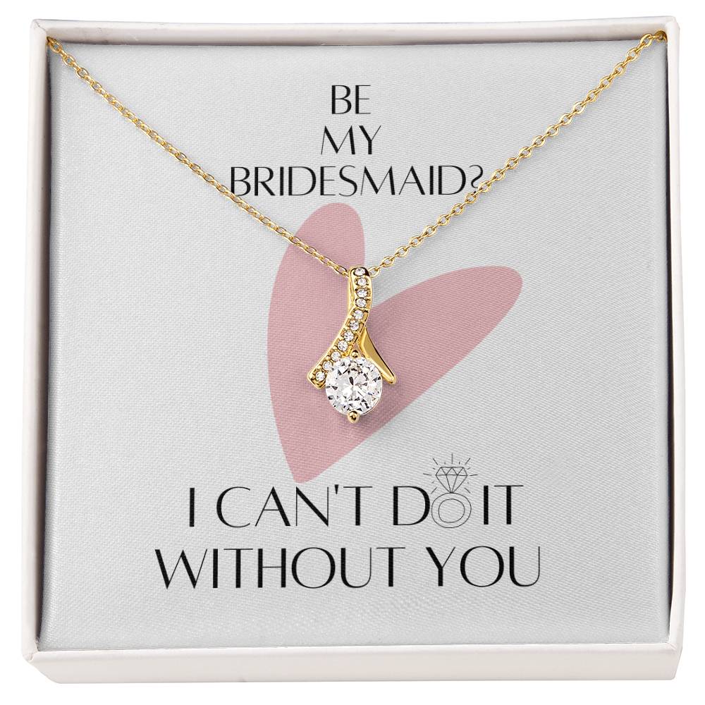 A necklace with ribbon shaped pendant made from cubic zirconia crystals and gold finish with a message card for bridesmaids in a  Jewelry gift box.