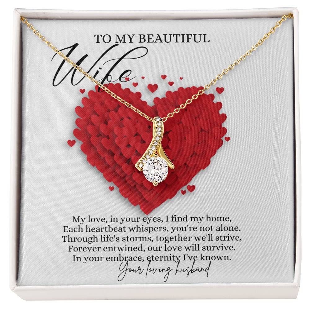 A necklace gift with ribbon shaped pendant with cubic zirconia crystals and a gold finish, with a message card to my beautiful wife in a Jewelry box.