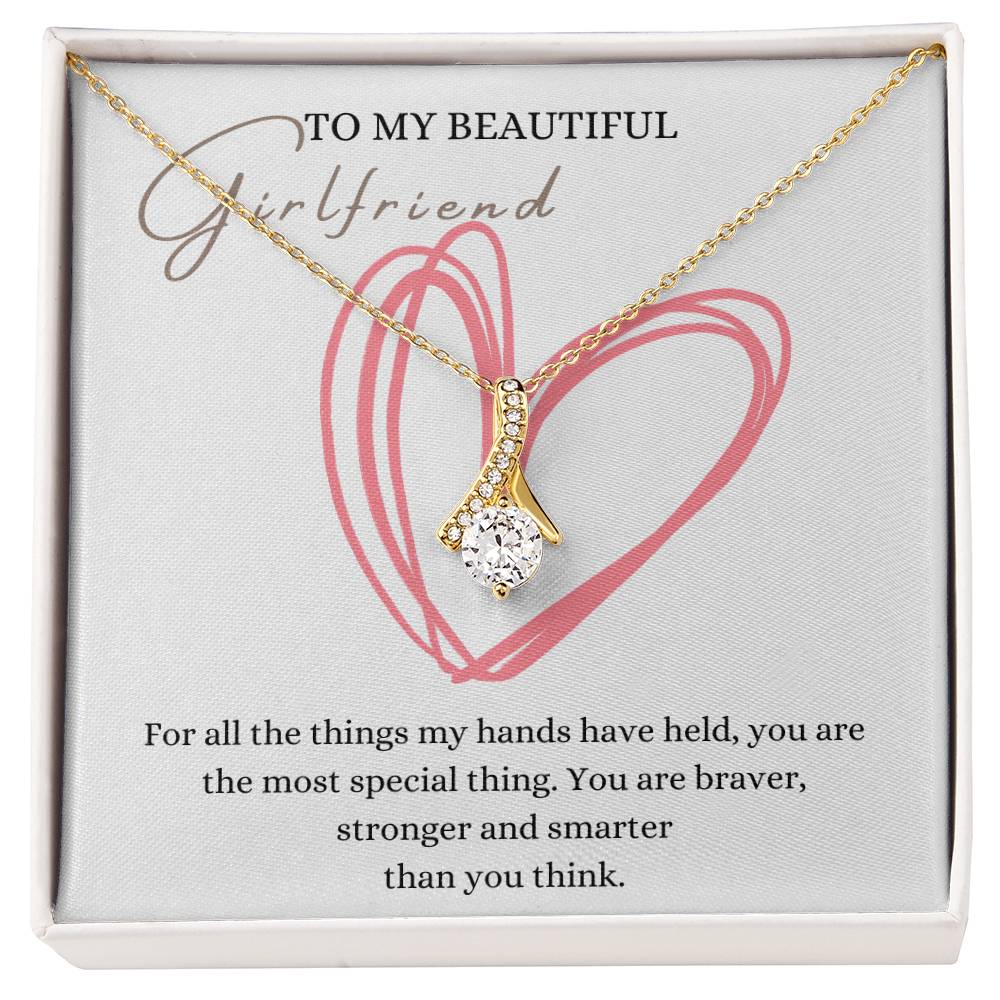 A necklace gift with ribbon shaped pendant with cubic zirconia crystals and a gold finish, with a message card to my beautiful girlfriend in a Jewelry box.