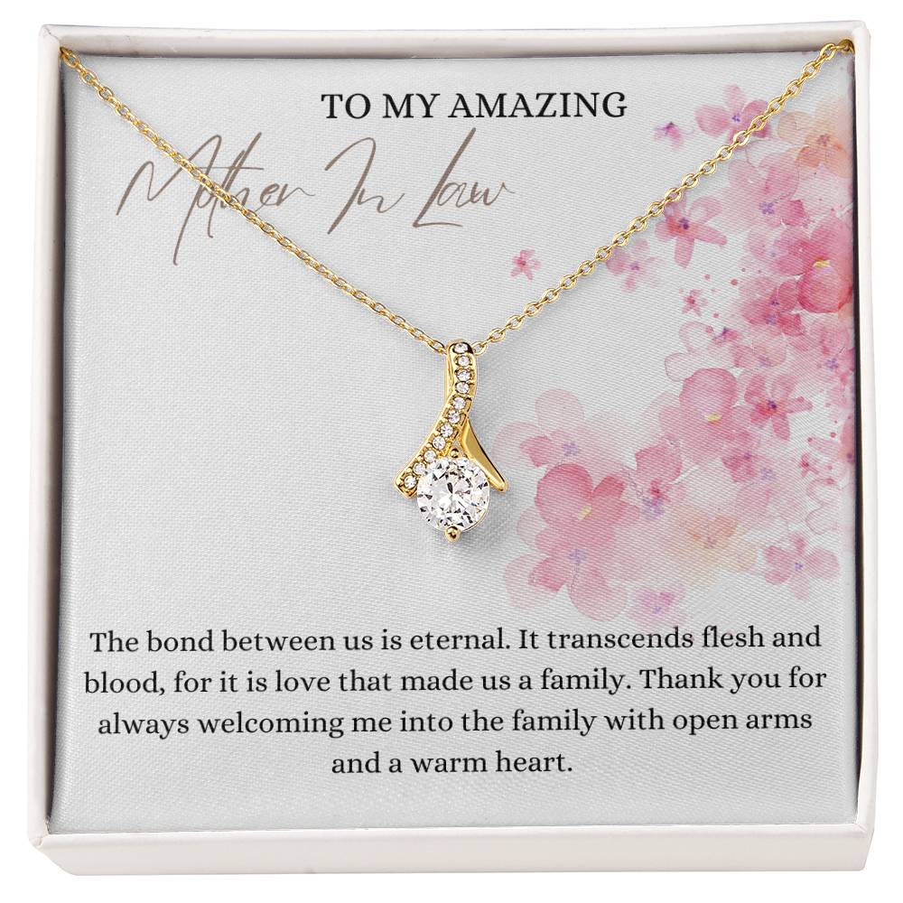 A necklace gift with ribbon shaped pendant with cubic zirconia crystals and a gold finish, with a message card to my mother in law in a Jewelry box.