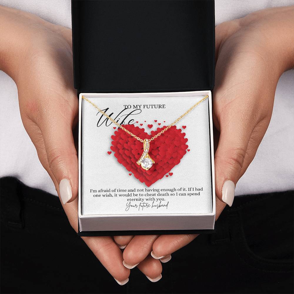 A woman presenting a mahogany Jewelry gift box with a necklace with ribbon shaped pendant made from cubic zirconia crystals and a gold finish, with a message card to my future wife.