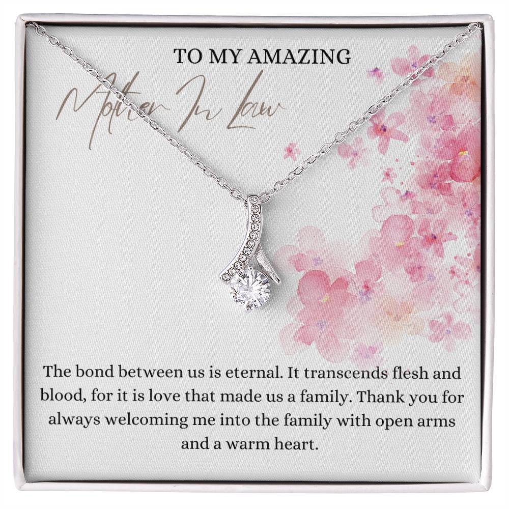 A necklace gift with ribbon shaped pendant with cubic zirconia crystals and a white gold finish, with a message card to my mother in law in a Jewelry box.