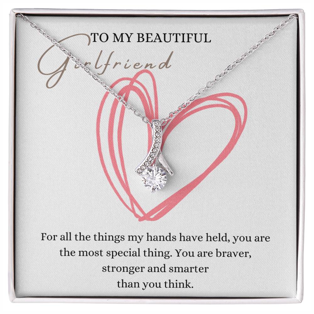 A necklace gift with ribbon shaped pendant with cubic zirconia crystals and white gold finish, with a message card to my beautiful girlfriend in a Jewelry box.