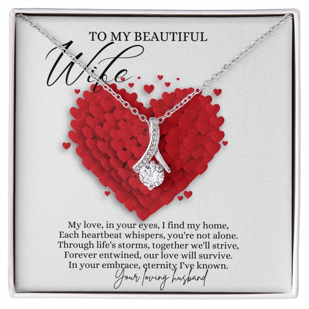 A necklace gift with ribbon shaped pendant with cubic zirconia crystals and a white gold finish, with a message card to my beautiful wife in a Jewelry box.