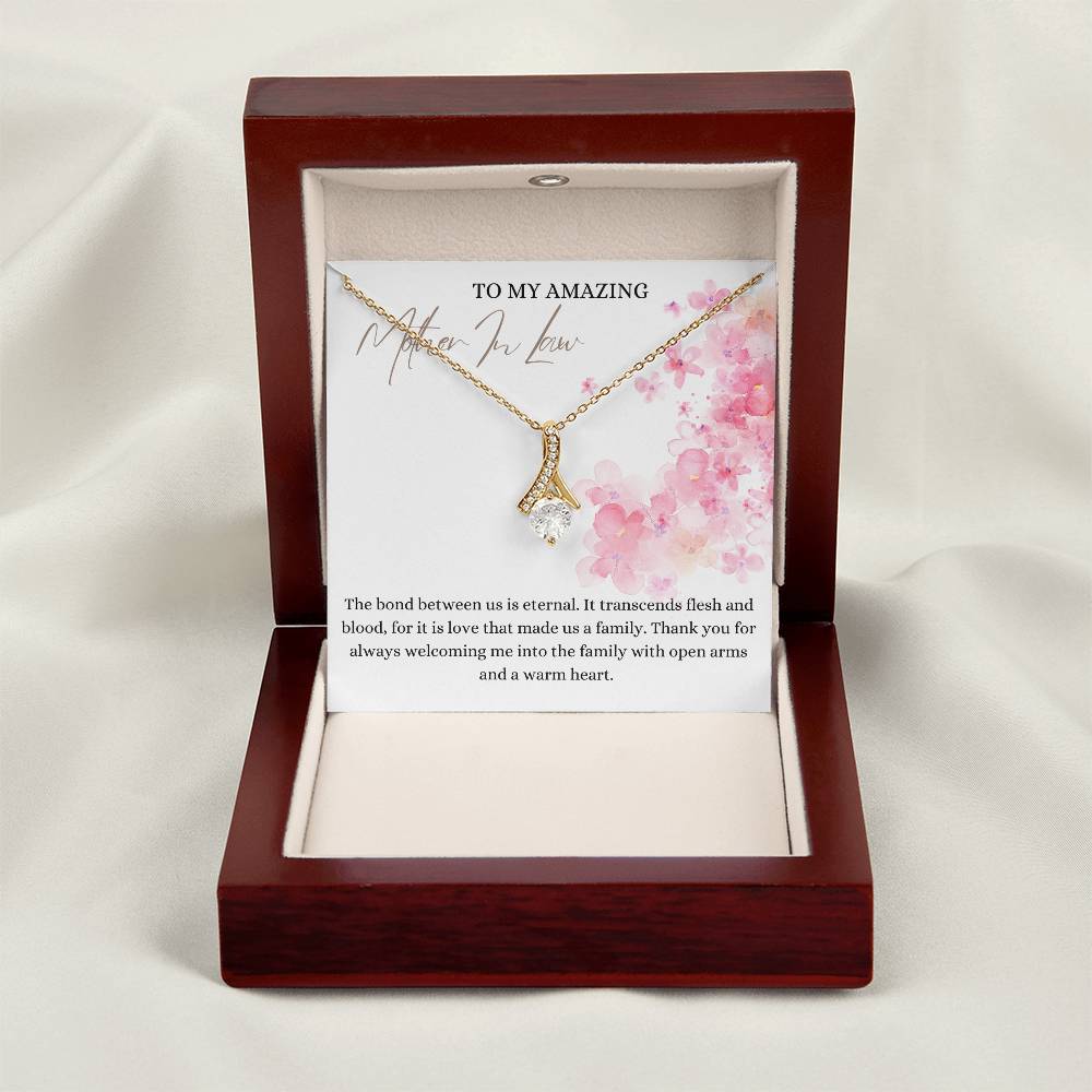 A necklace gift with ribbon shaped pendant with cubic zirconia crystals and a gold finish, with a message card to my mother in law in a mahogany Jewelry box.