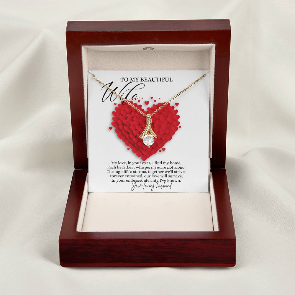 A necklace gift with ribbon shaped pendant with cubic zirconia crystals and a gold finish, with a message card to my beautiful wife in a mahogany Jewelry box.