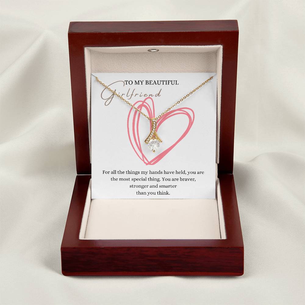 A necklace gift with ribbon shaped pendant with cubic zirconia crystals and a gold finish, with a message card to my beautiful girlfriend in a mahogany Jewelry box.