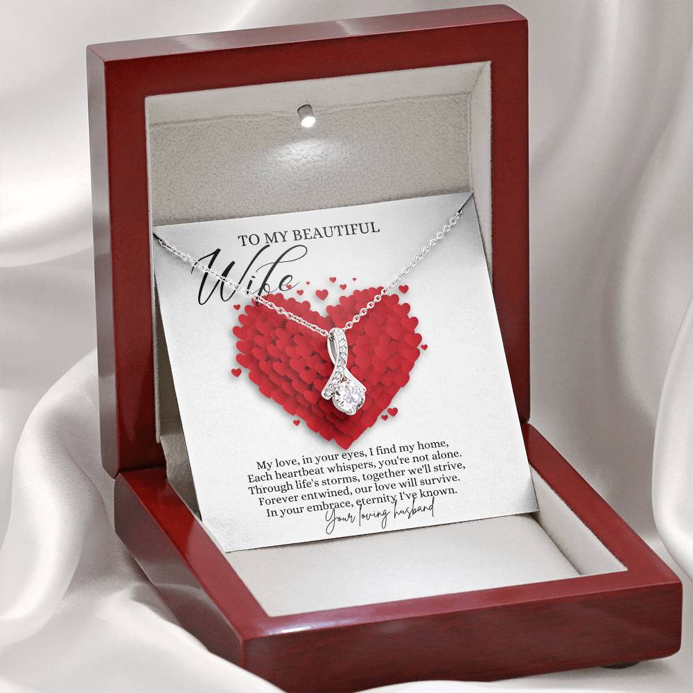 A necklace gift with ribbon shaped pendant with cubic zirconia crystals and white gold finish, with a message card to my beautiful wife in a mahogany Jewelry box.
