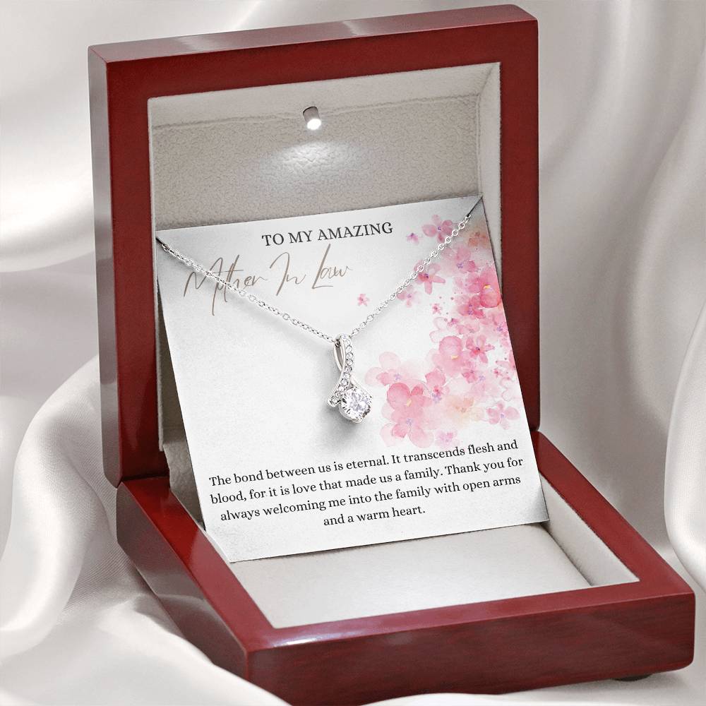 A necklace gift with ribbon shaped pendant with cubic zirconia crystals and white gold finish, with a message card to my mother in law in a mahogany Jewelry box.