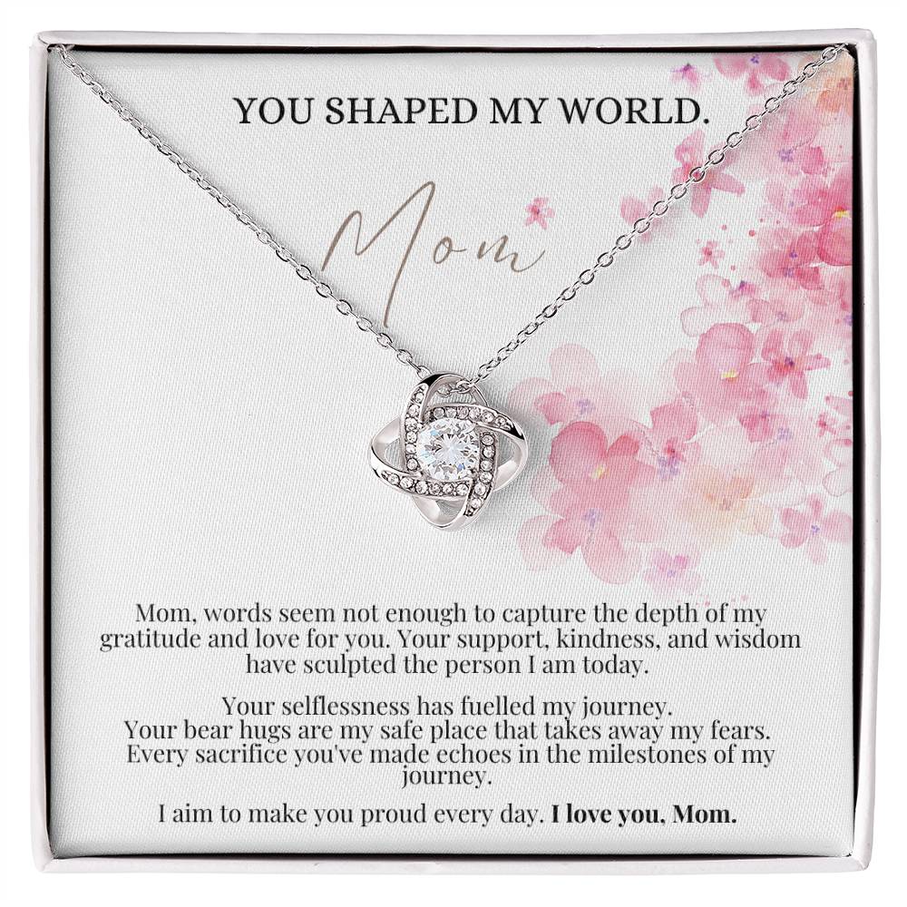 A white gold finish necklace gift, with a knot pendant embellished with premium cubic zirconia crystals, and a message card to mom, in a Jewelry box.