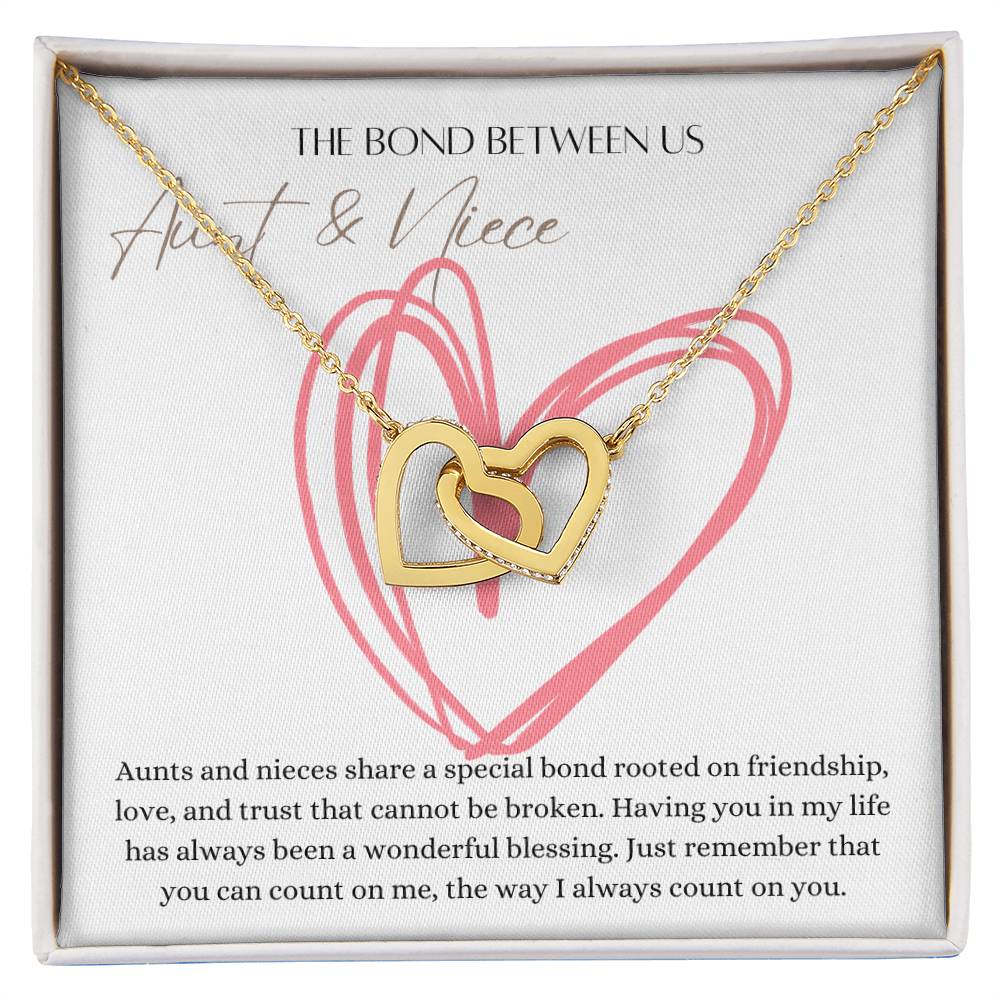 A necklace with two connected hearts embellished with with cubic zirconia crystals and white gold finish with a message card for aunt's and niece's.