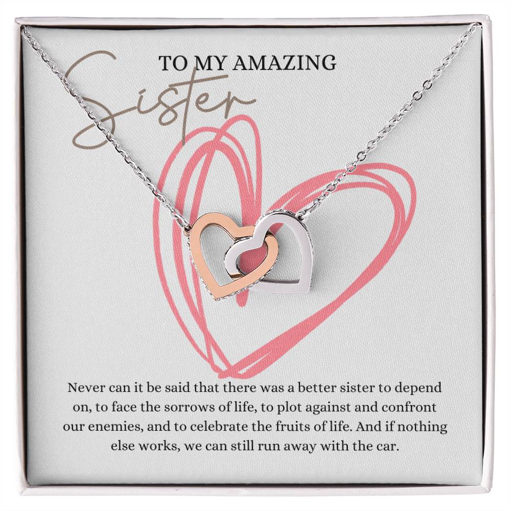 A necklace gift in a Jewelry box, with ribbon shaped pendant with cubic zirconia crystals and white gold finish, with a message card to my amazing sister.