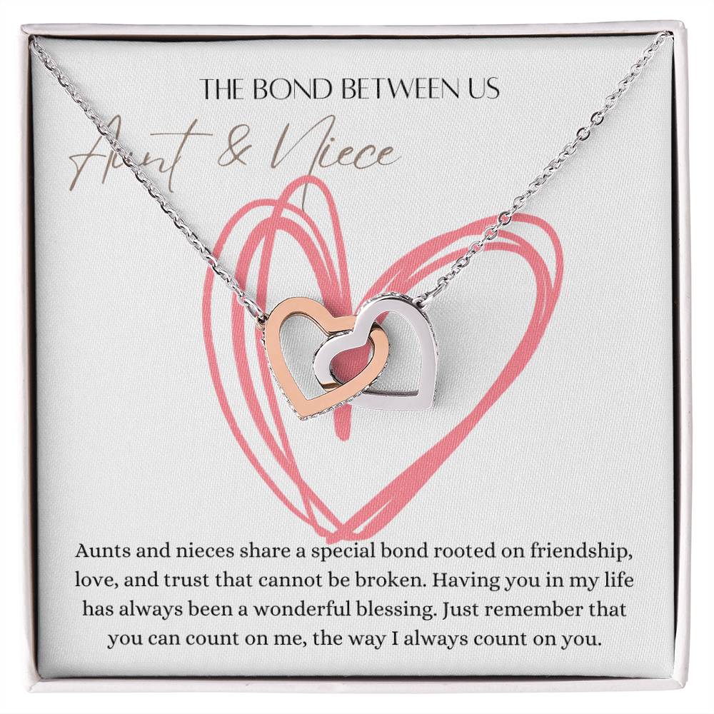 A necklace with two connected hearts embellished with with cubic zirconia crystals and white gold finish with a message card for aunt's and niece's.