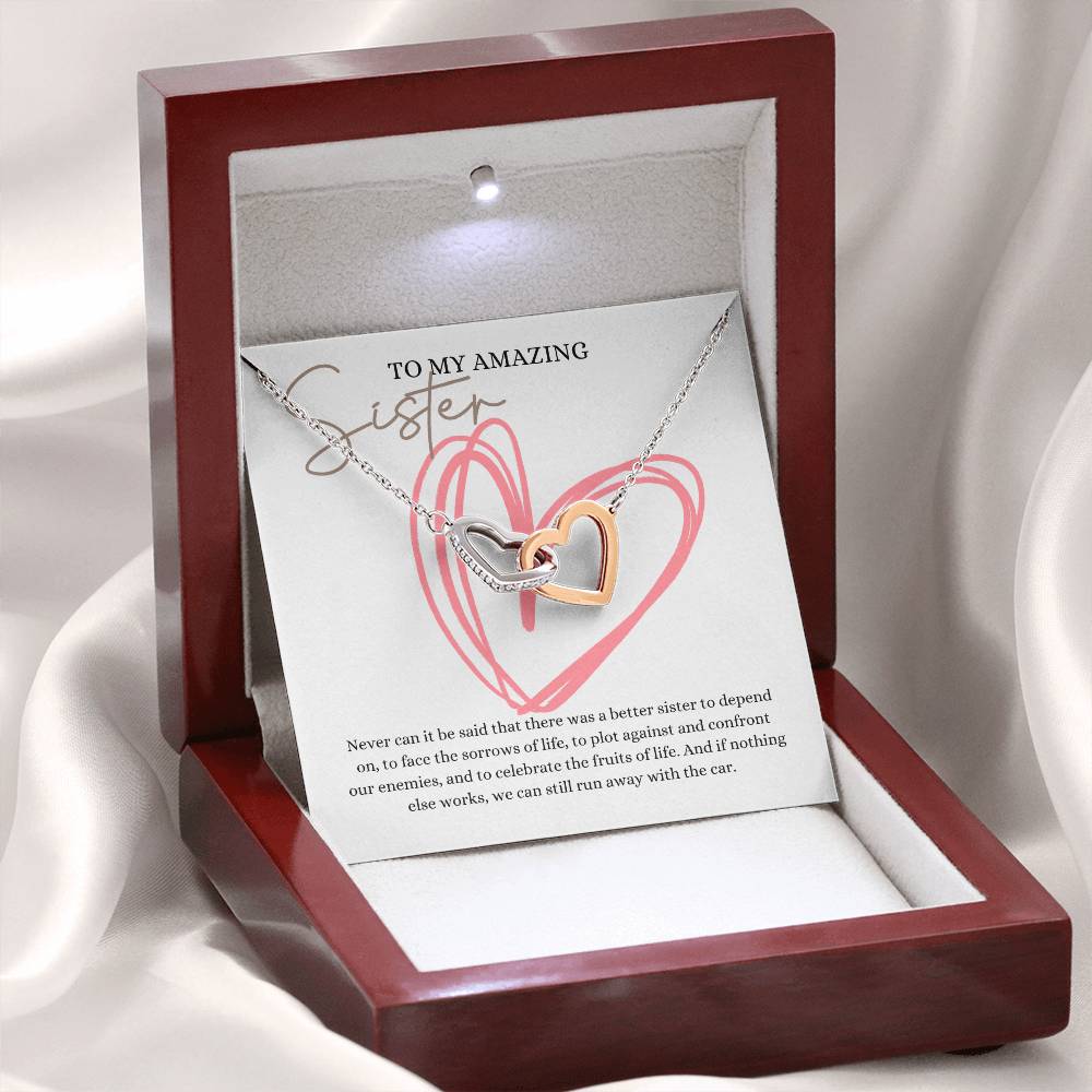 A mahogany Jewelry box, with a necklace with two connected hearts embellished with cubic zirconia crystals and white gold finish, with a message card to my amazing sister.