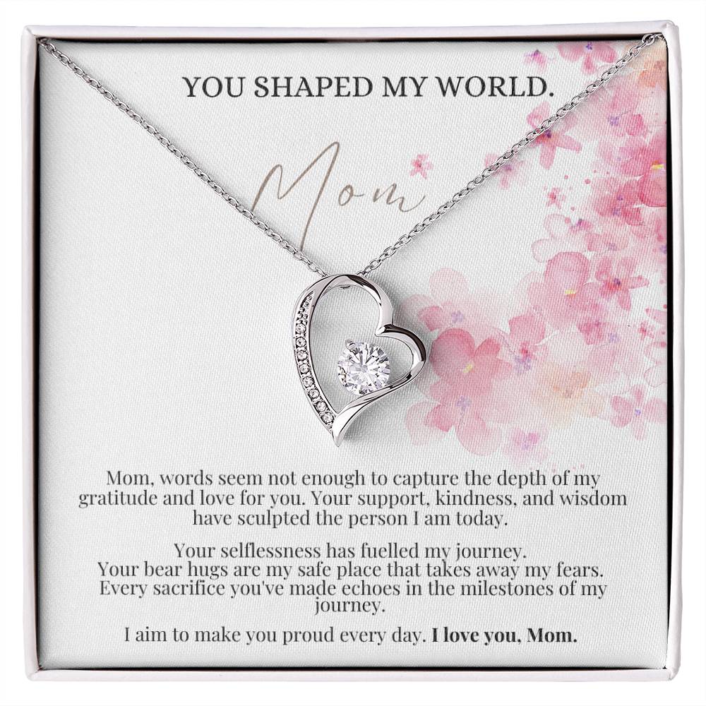 A white gold finish necklace gift, featuring a stunning 6.5mm CZ crystal surrounded by a polished heart pendant embellished with smaller crystals, with a message card to mom in a Jewelry box.